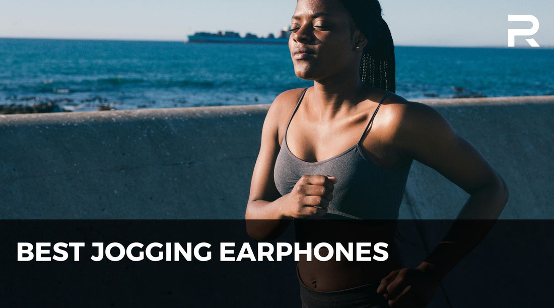 Woman jogging by the ocean under sunlight, wearing wireless earbuds, promoting best jogging earphones for outdoor running