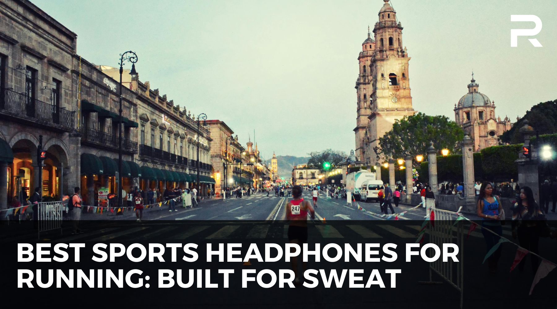 Street race event in a historic city center, with runners and spectators, promoting best sports headphones for running built for sweat and endurance training